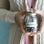 Woman holding a jar labelled savings for a one-year savings goal